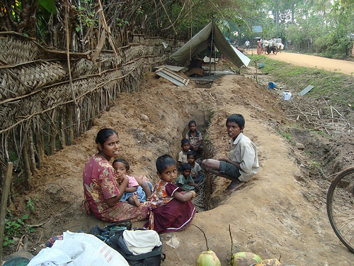 Tamil family sit by a trench in the LTTE-occupied "No Fire Zone" (Human Rights Watch)